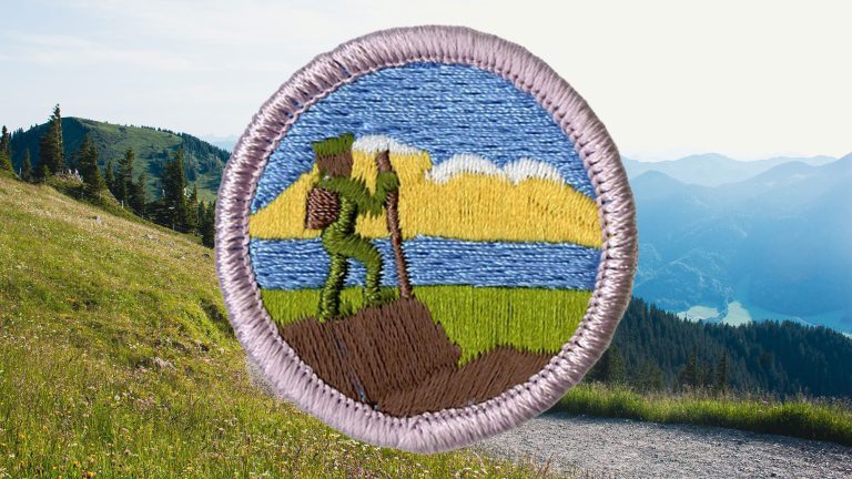 Hiking merit badge patch over hiking trail